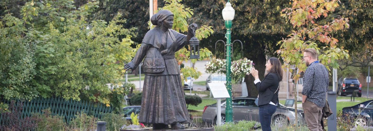 Visitors stand in front of the Harriet Tubman statue and takes pictures.